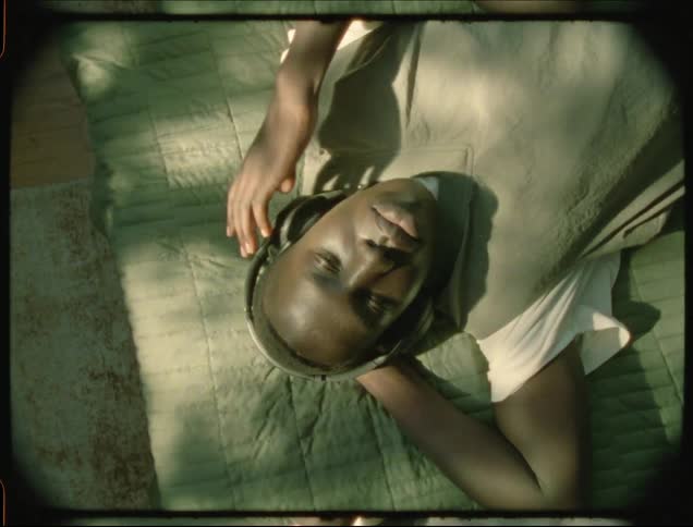 Overhead view of a man wearing headphones lying on a bed