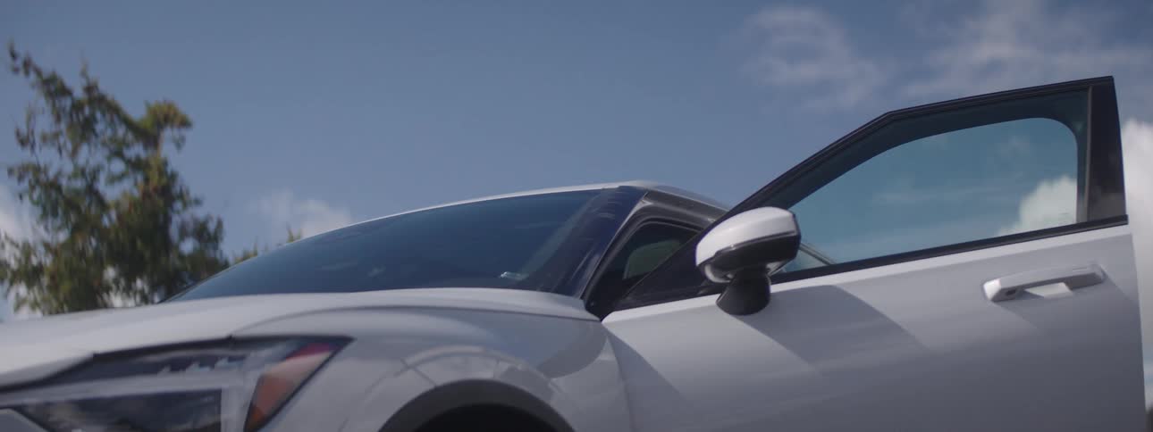 Woman getting into a white car and closing the door