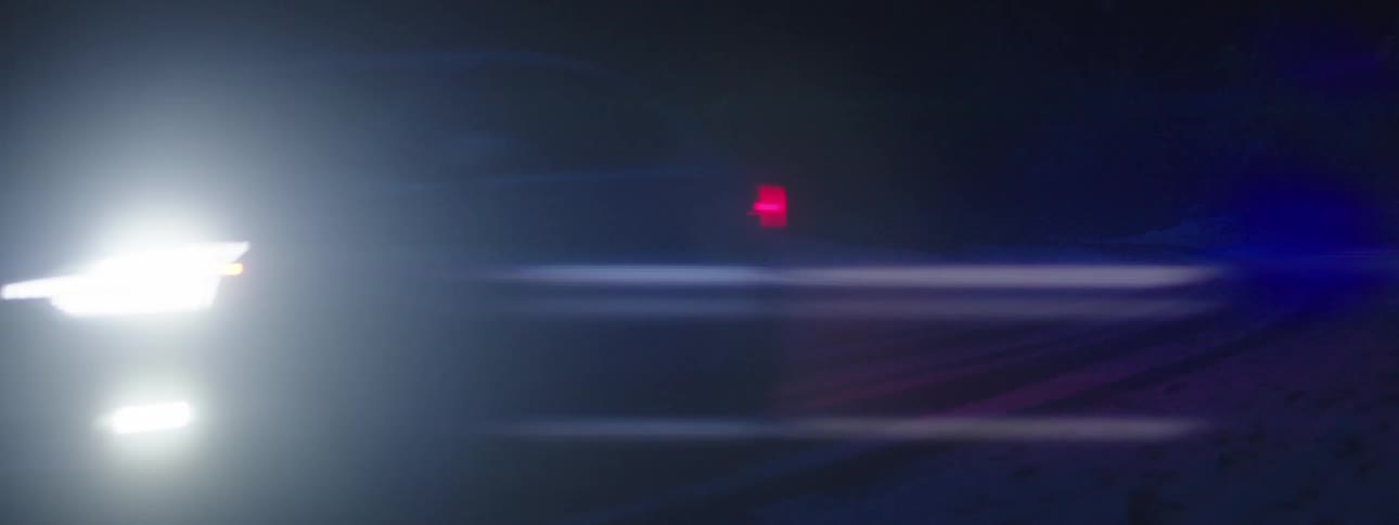 A car drives on the snow at night