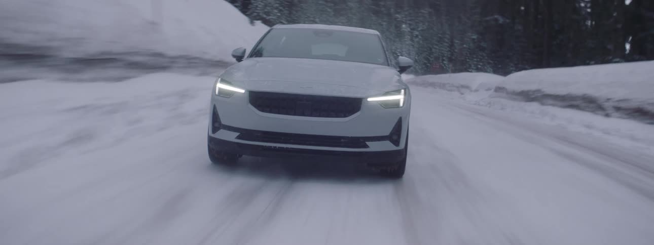 A white car driving on a snowy road in the mountains