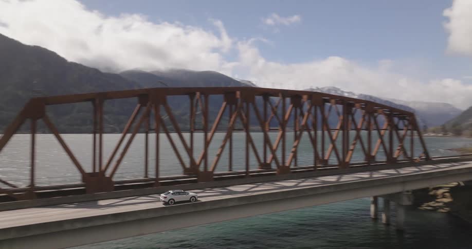 A car drives over a river bridge