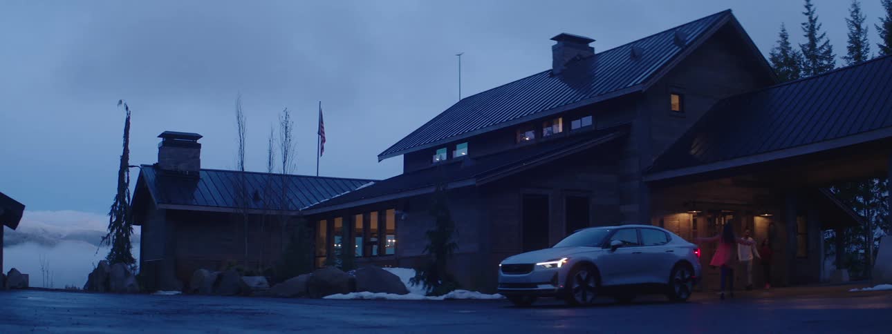 Woman getting out of the car and going towards her family and hugging them outside on a cloudy late afternoon