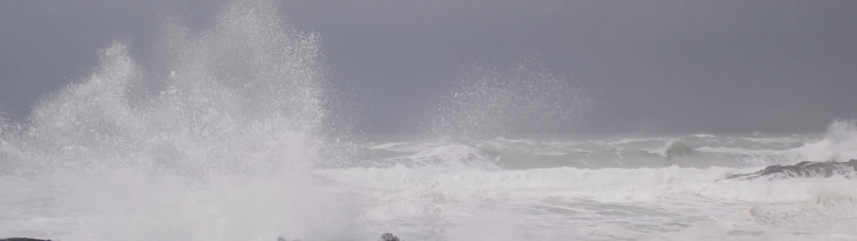 Large waves in a stormy sea crashing hard into coastal rock formations