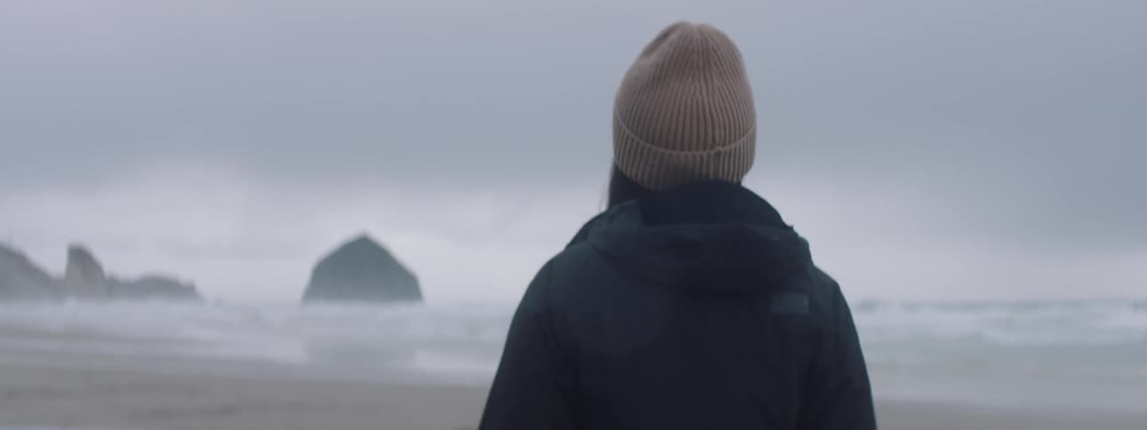 A clip of a person walking by the sea shore during winter