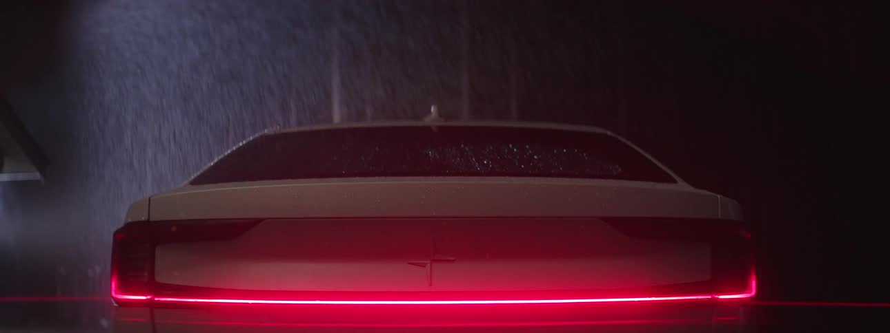 A car in the rain turns off its blinkers and turns on read break lights that fade in gradually