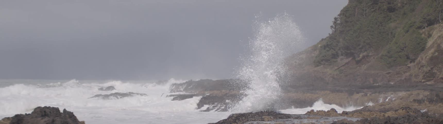 Large waves in a stormy sea crashing hard into coastal rock formations