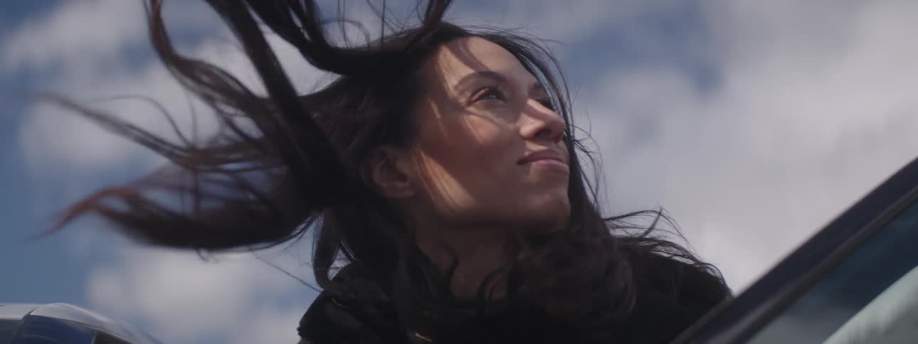A woman is looking around on a windy day