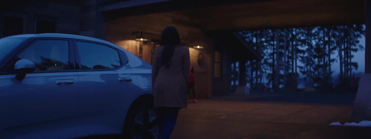 A woman gets out of her car and greets a man