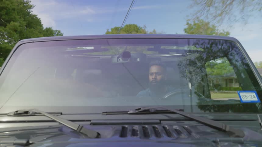 A man and his dog take a ride in a vehicle
