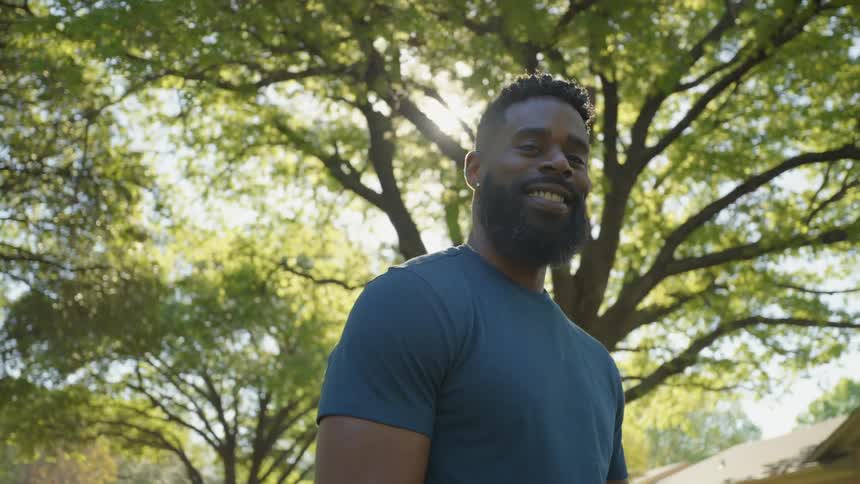 A black man standing and smiling in a suburb
