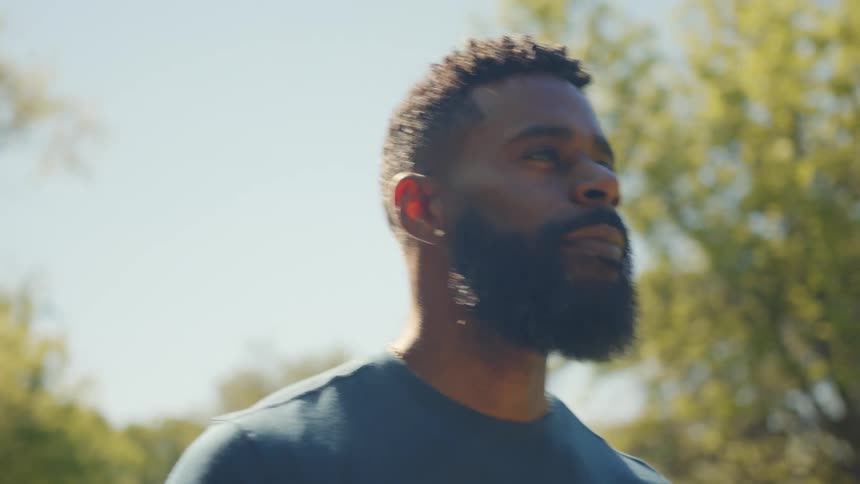 A man is walking on a sunny day