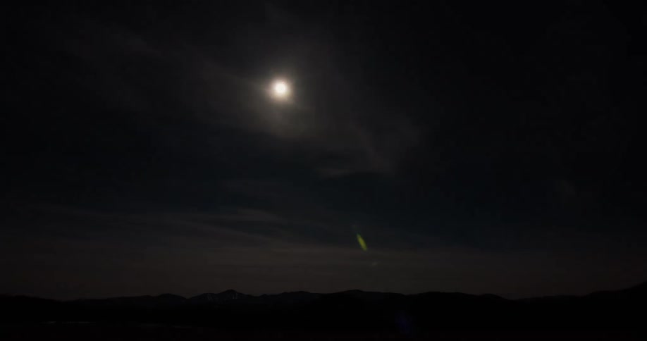 Time passes quickly over mountains as the sun flares and goes dark