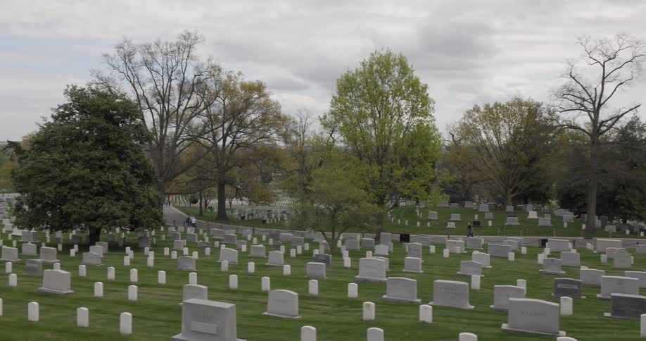 Several people walking through a cemetery