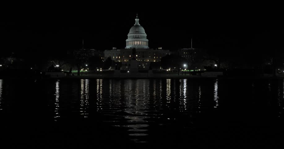 Panorama of a calm lake and the washington capitol in the background illuminated at night