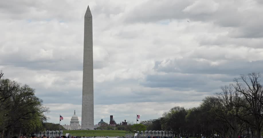 A view of the washington monument with the capitol building in the distance