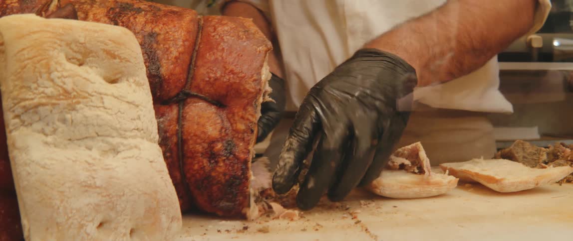 A restaurant worker prepares pulled meat sandwiches