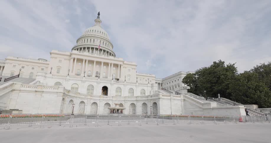 The united states capitol building with a clear sky and barricades in the foreground