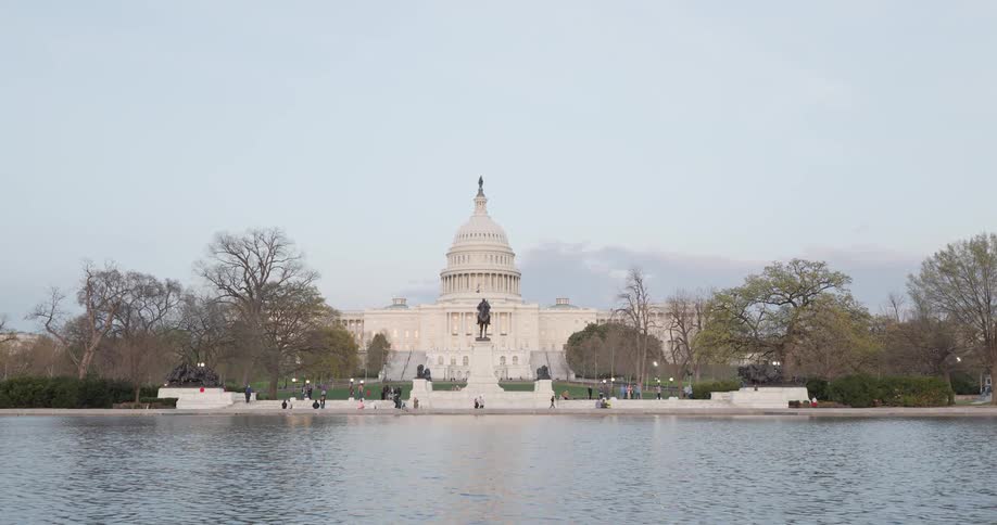 Washington capitol in front of a calm lake during the day