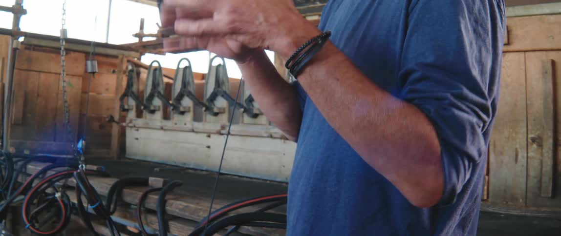 A person in a blue shirt explaining something in front of machinery
