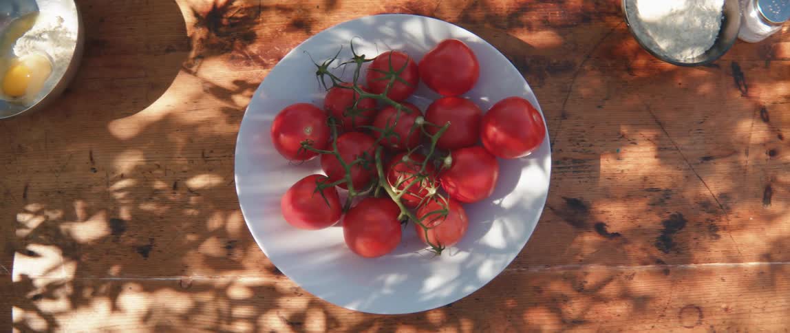 A plate of tomatoes on a wooden table