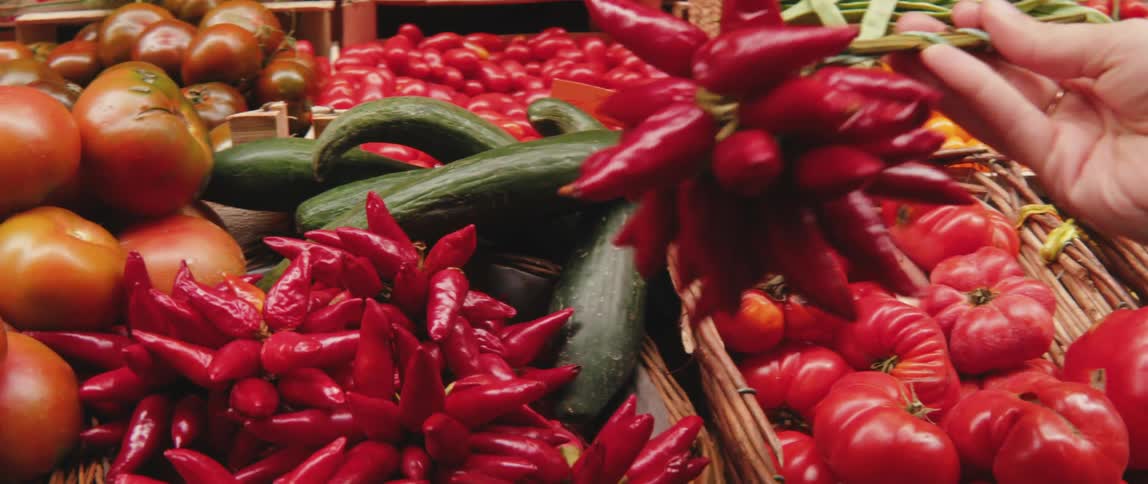 A customer picks up peppers and puts them back down