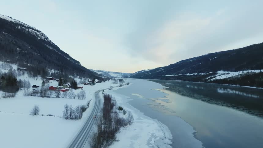 Aerial view of a landscape with a lake and snowcovered mountains
