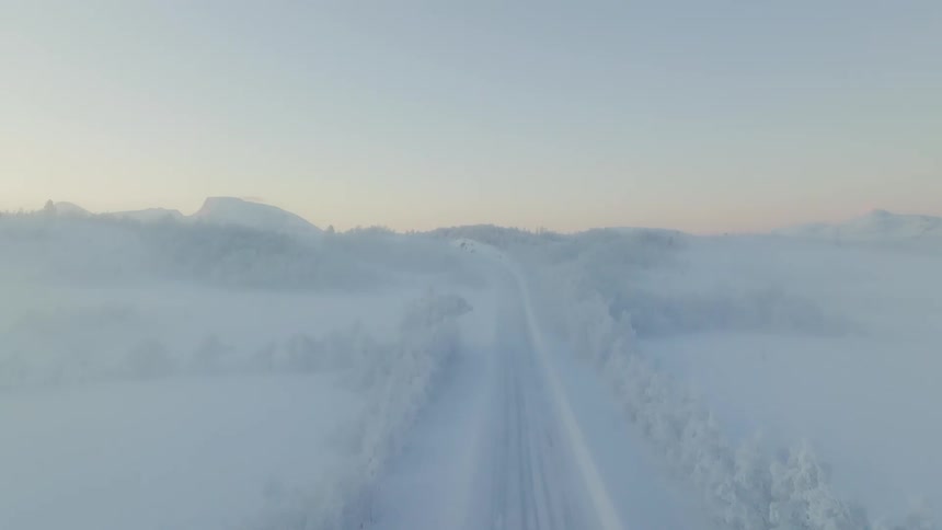 A street and all the flatland around it is covered in snow