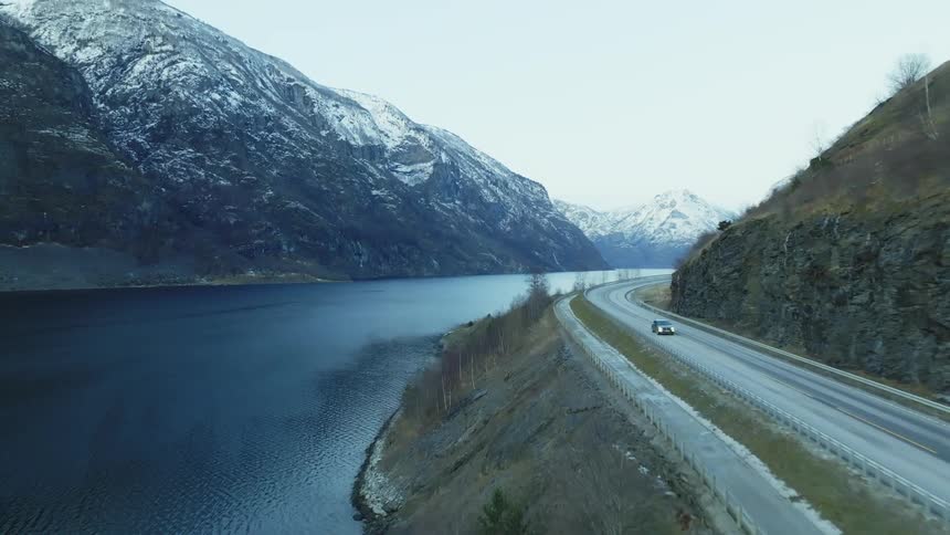 Cars travel on the road by the river