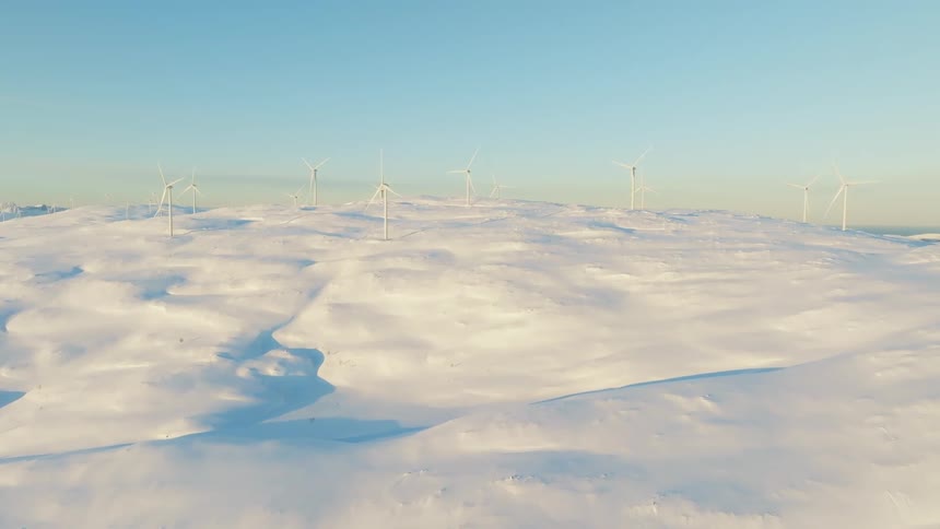 Aerial view of wind energy platforms in motion on a snowcovered ground