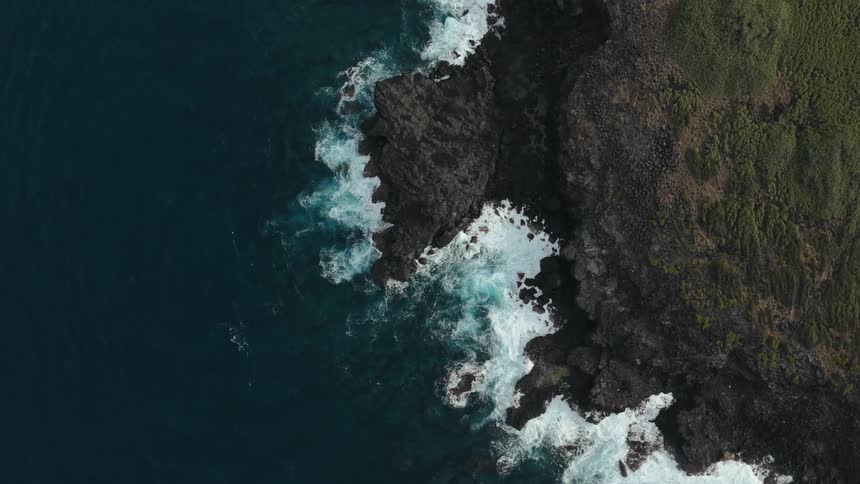 Waves foam againstthe rocky coast