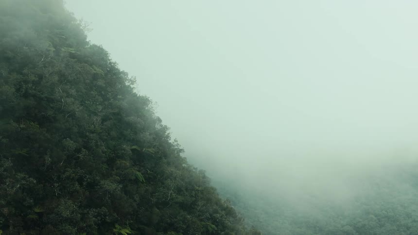 Fog hovers over a mountain and valley