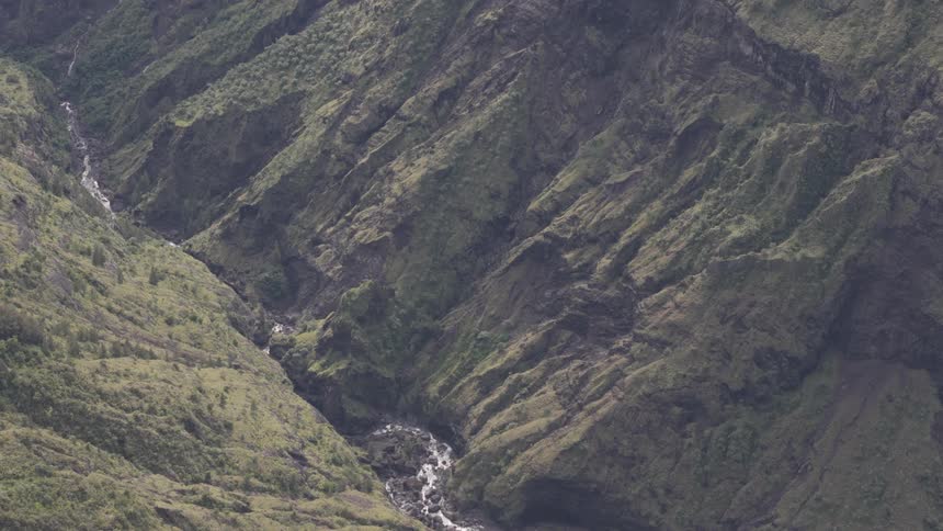 Aerial landscape of rocky mountains with greenery and a river in the middle