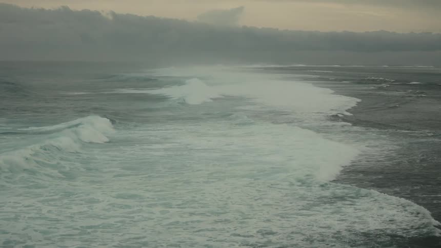 Aerial panorama of the sea with waves in a morning sky with clouds