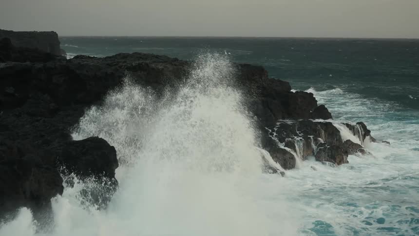 Huge waves pound an entirely rocky shore