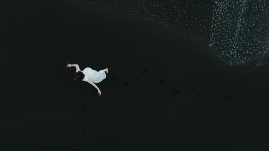 An aerial clip of a lady at the sea shore