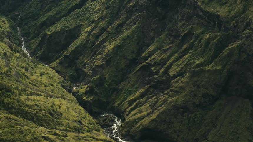 Aerial of a stream in the valley of a mountain range