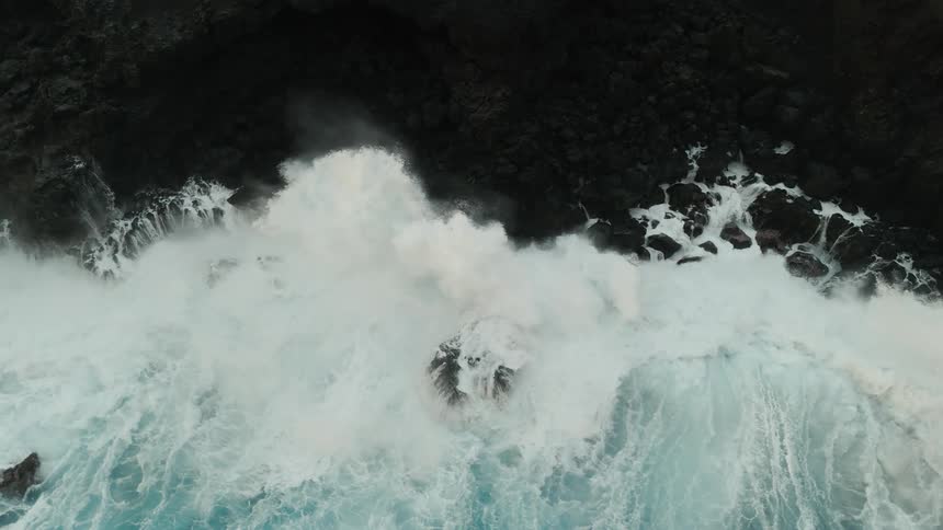 Ocean waters washing the black rocky coast