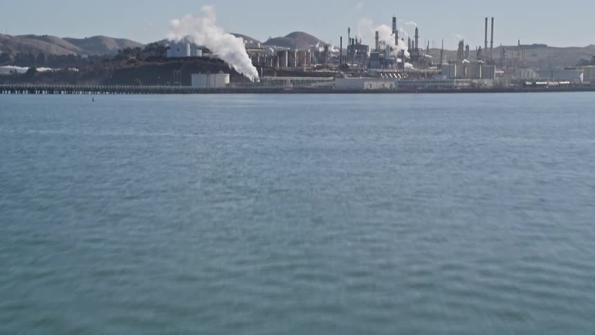 A refinery sits on a coastal area