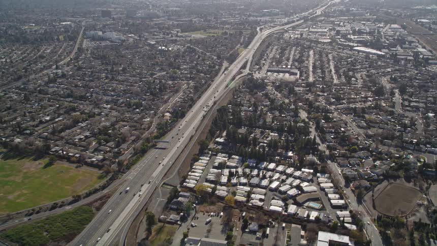 Aerial view of a highway running through a residential area with houses on either side