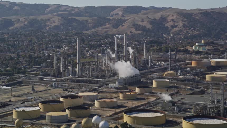 Aerial view of an oil refinery mountains and urban cityscape