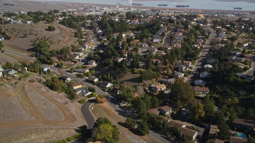 An aerial view of a suburb with several houses and many trees in the region