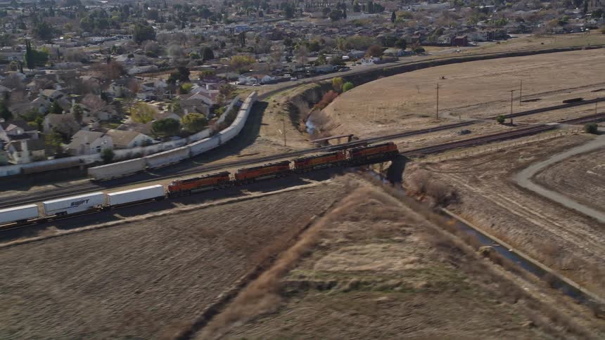 A train rolls by a large suburban area