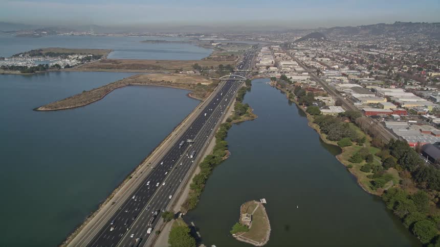 Traffic drives on a road along a coastal city