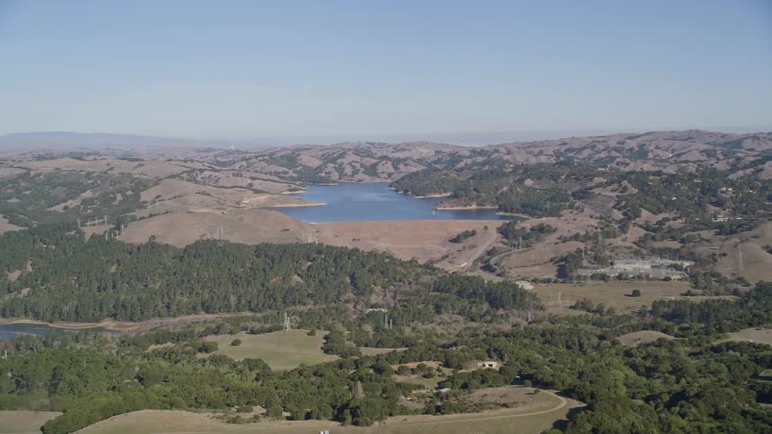 Aerial view of the countryside with a lake and hills in the distance