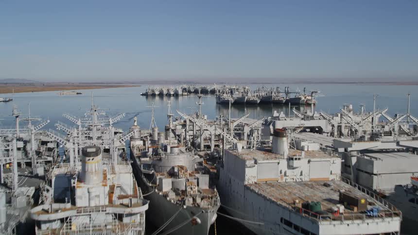 Large military style boats tied together in the water