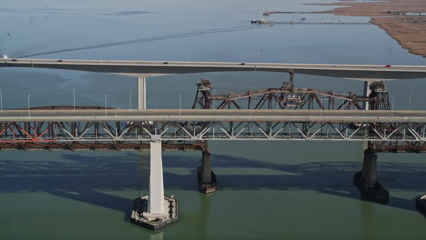 Cars drive over two bridges close to a rural community