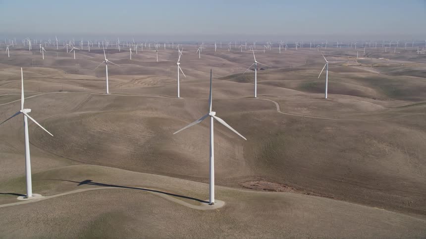Aerial view of a desert scattered with wind turbines