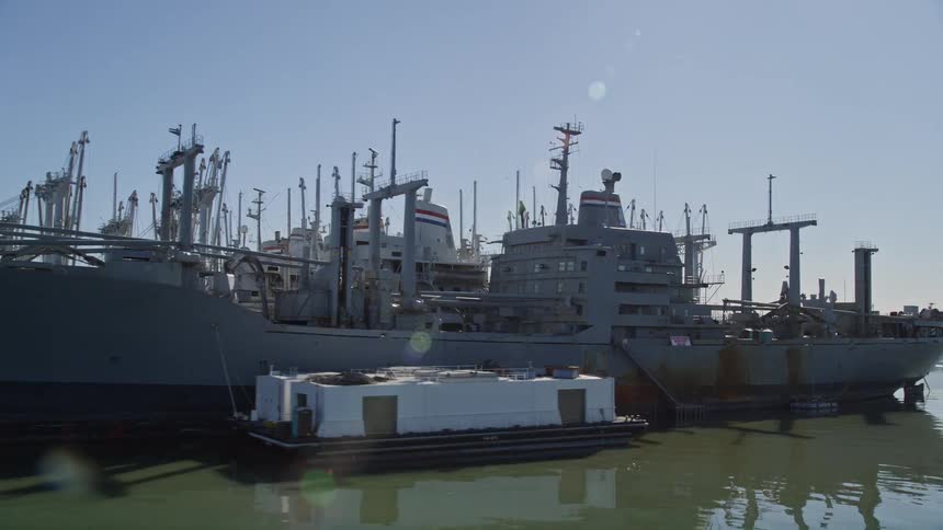 A clip of naval ships in the harbor