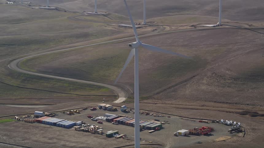 Aerial panorama of wind energy engines in natural fields and outdoors