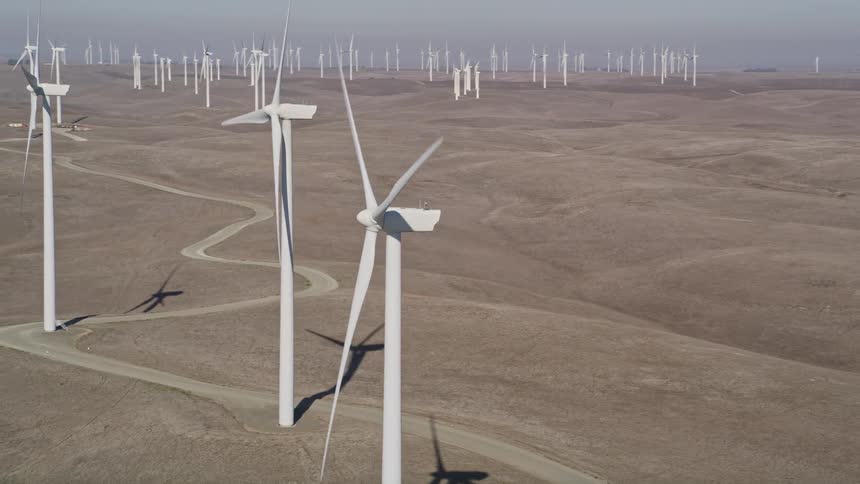 Aerial scenery of wind power engines in natural fields during a cloudy day